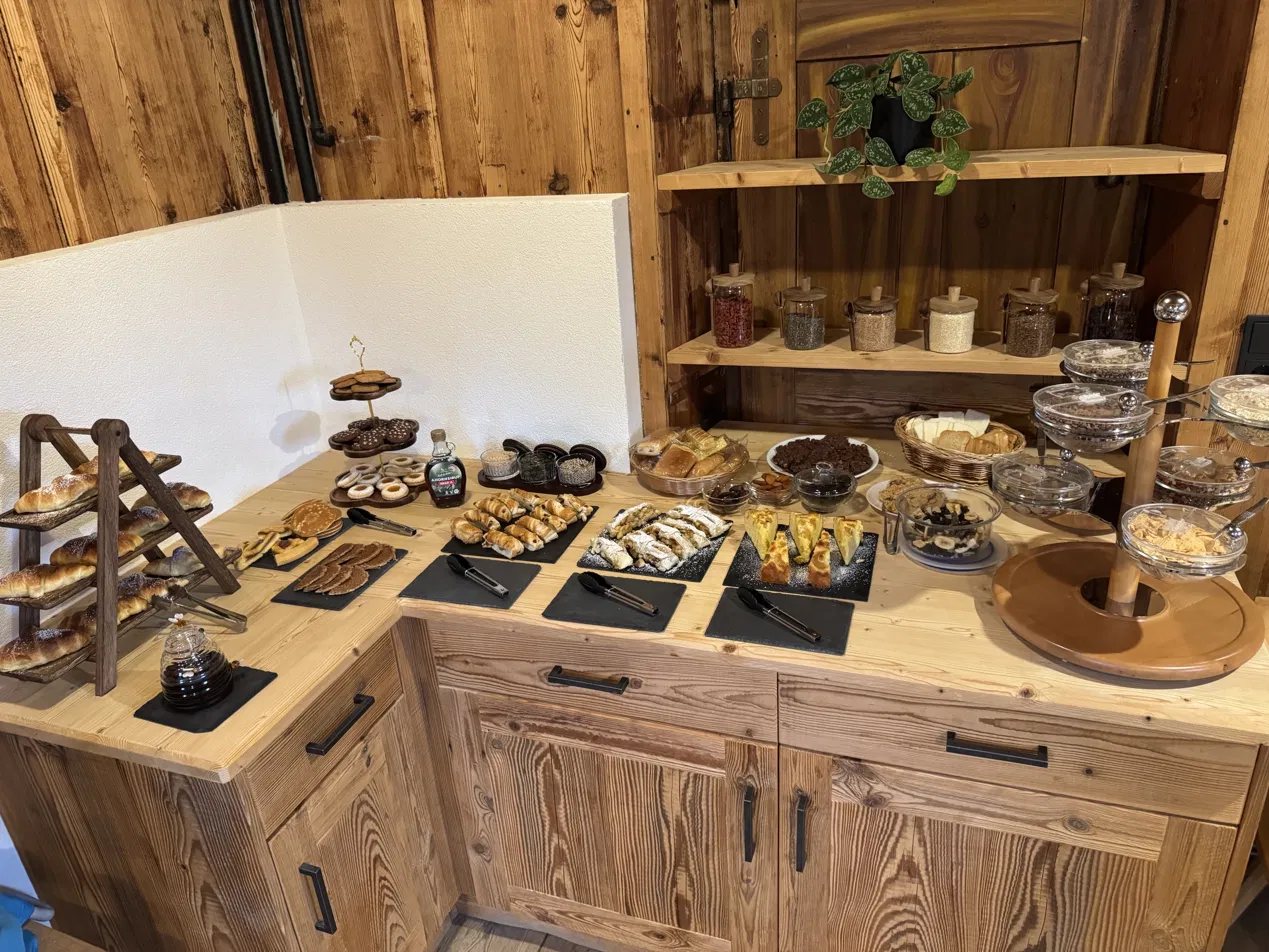 Frühstücksbuffet mit Gebäck, Strudel, Kuchen und Müsli auf Altholz