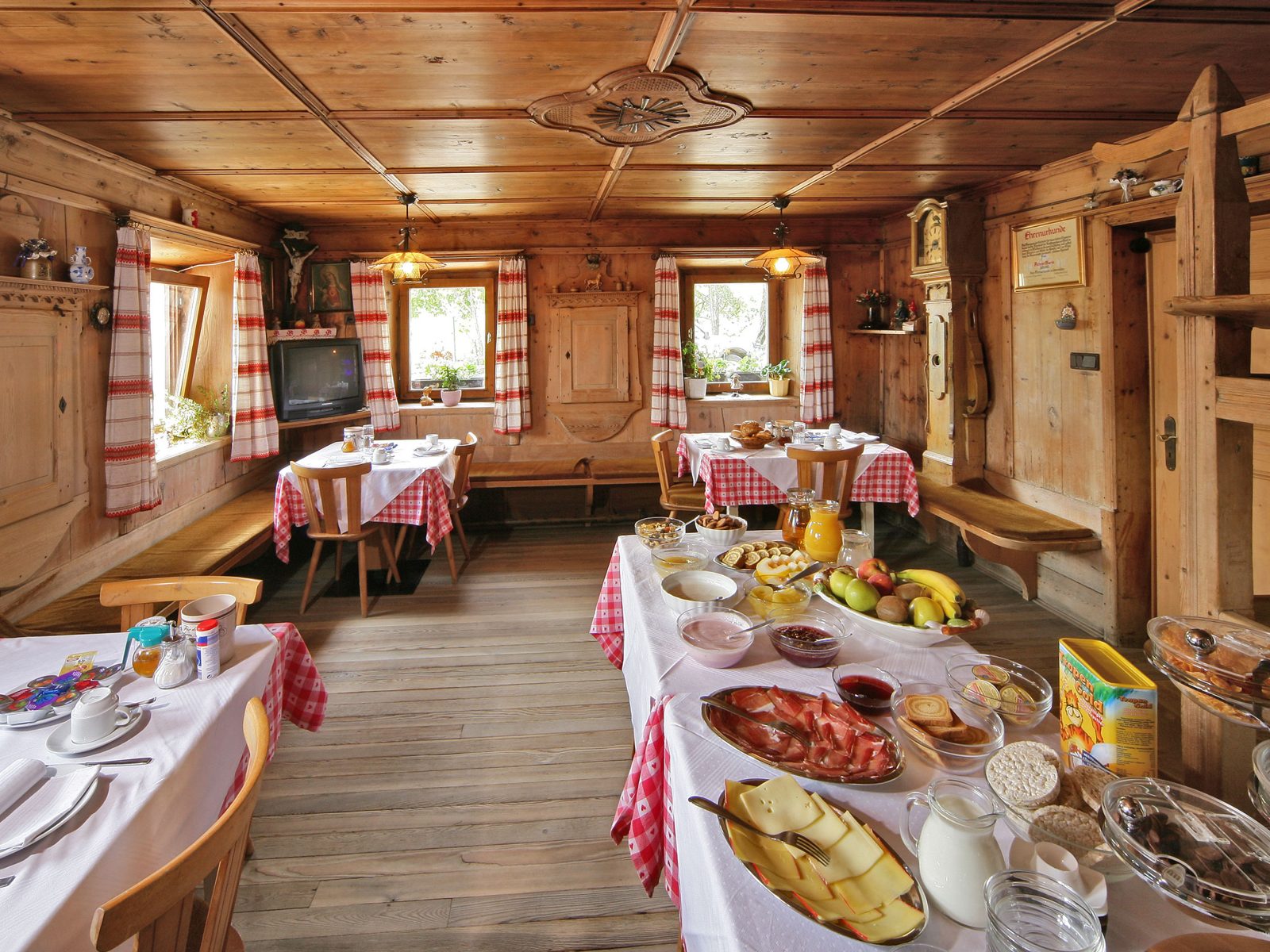 Alte Bauernstube von etwa 1850 mit Holzdecke, Kachelofen und gedeckten Tischen